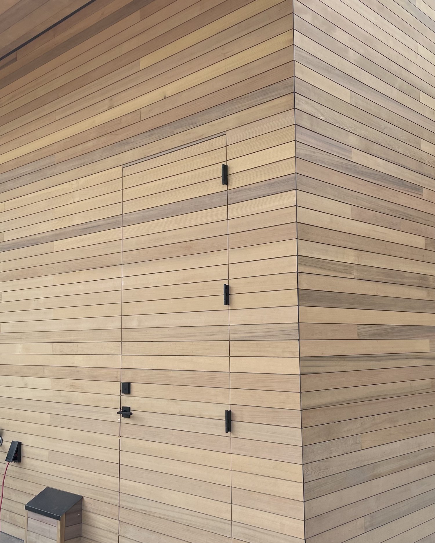 Mitered cedar-clad corner with a concealed flush access door